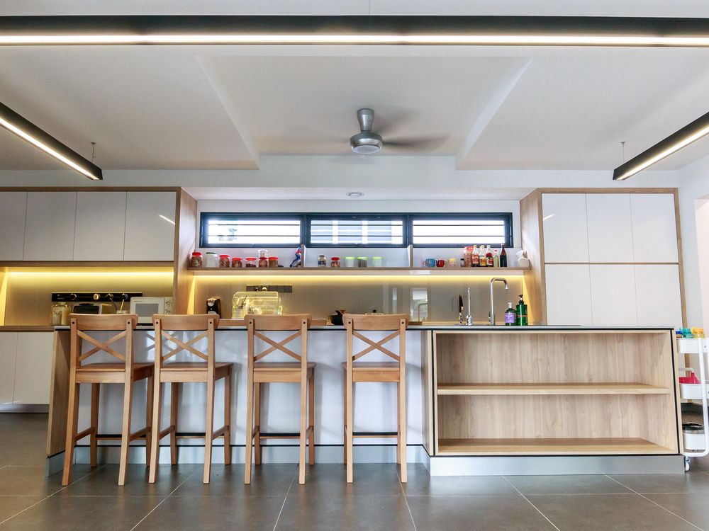 Kitchen with an island counter, bar stools and under-cabinet lighting