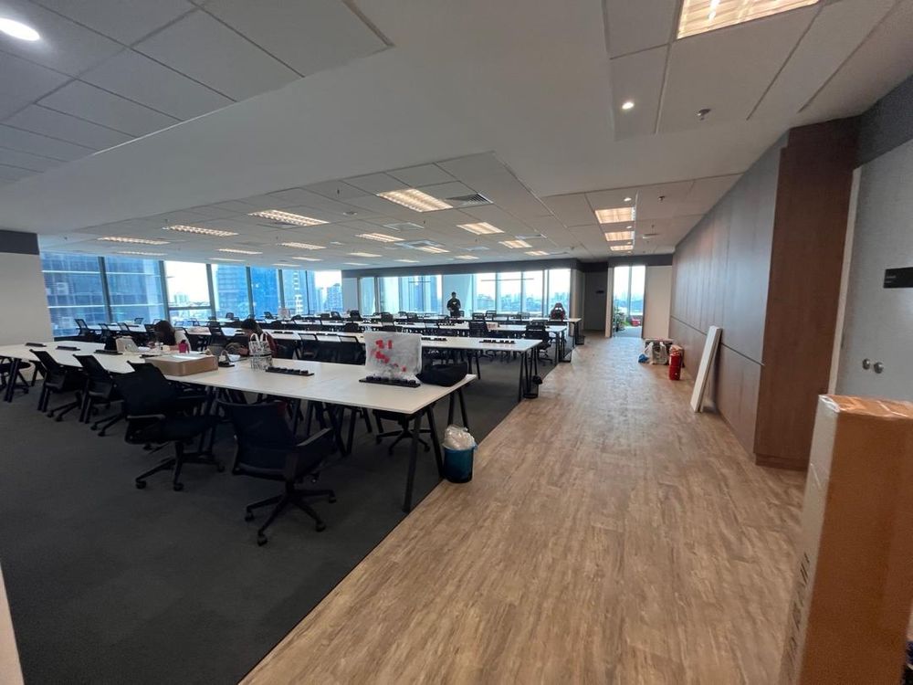 Open-plan office with workstations, carpet and timber-look walkway
